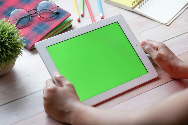 Person reviewing templates on a tablet — deciding between Beacon&rsquo;s pre-made designs before customizing one for their audience