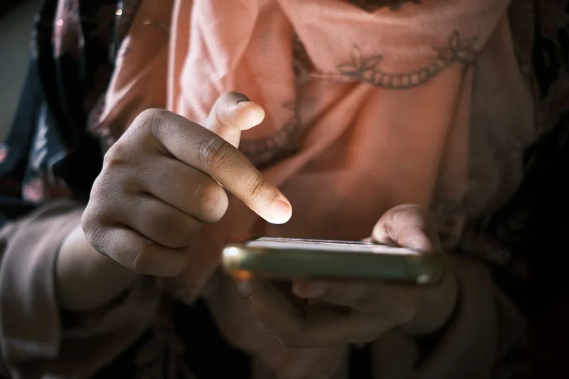 Close-up of hands using a smartphone, representing checking a lead magnet delivery email on mobile