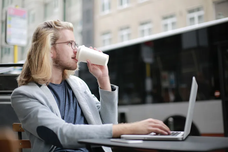 A person sitting outdoors with a laptop, working on social media content strategy and repurposing their lead magnet into posts