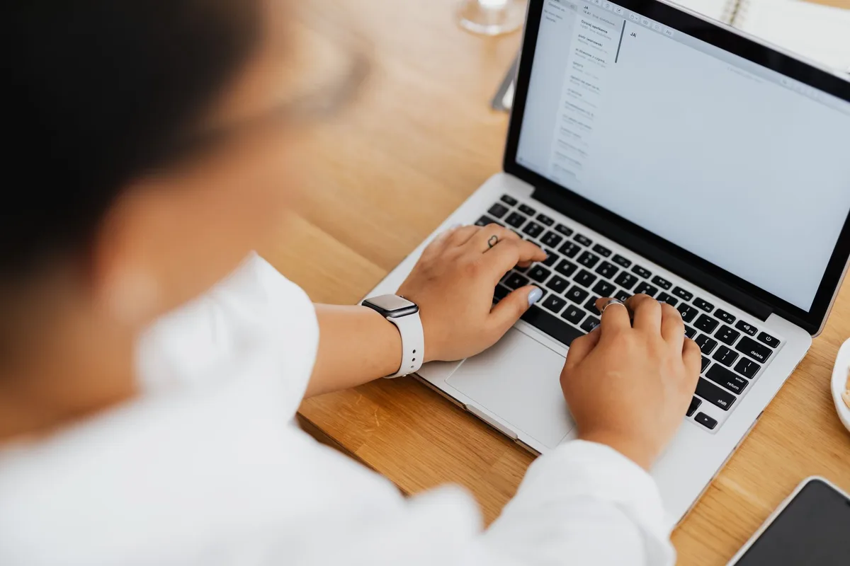 Person setting up automated email delivery on a laptop to send a lead magnet to new subscribers