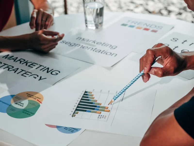 Marketing team reviewing strategy documents and charts, representing the importance of matching content format to audience needs