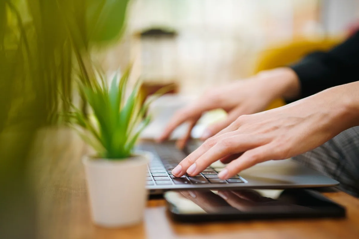 Hands typing on a laptop while setting up an email automation for a new lead magnet