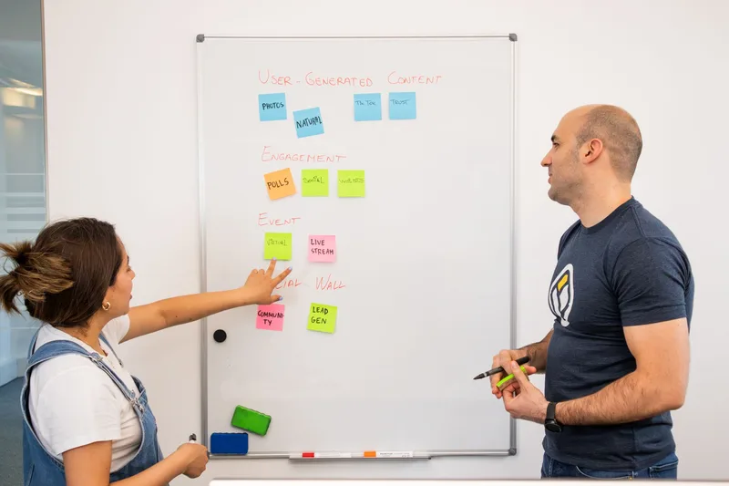 Two professionals brainstorming and planning categories on a whiteboard
