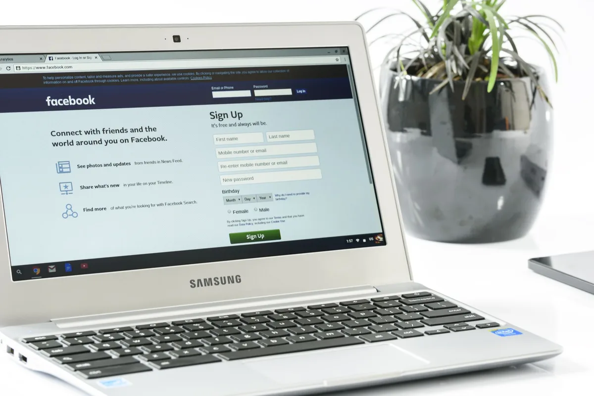 A laptop open on a website homepage with an email signup form visible above the fold
