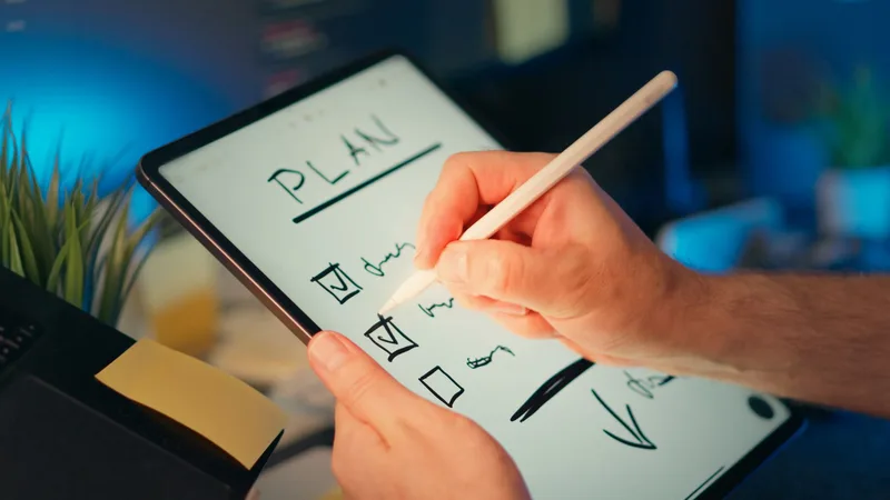 A hand writing a checklist labeled &ldquo;Plan&rdquo; on a digital tablet using a stylus